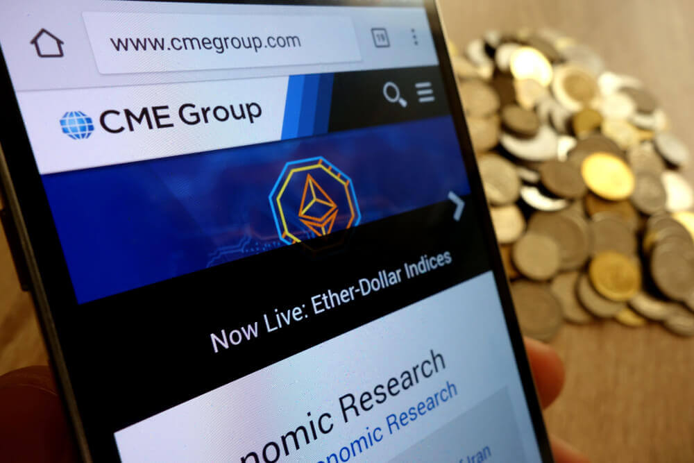 a website of CME is being shown on a phone