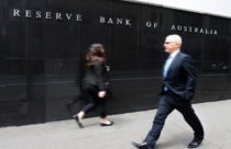 Finance Brokerage - foreign exchange trading: Man and woman in suit walking in front of the Reserve Bank of Australia