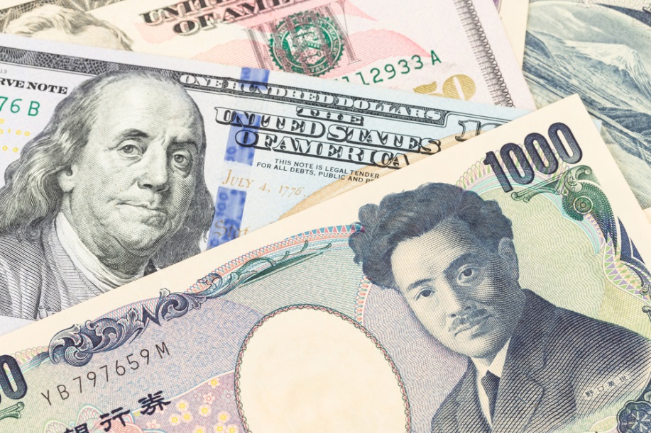 Finance Brokerage – Foreign exchanges trading: Dollar and yen banknotes stacked on top of each other.