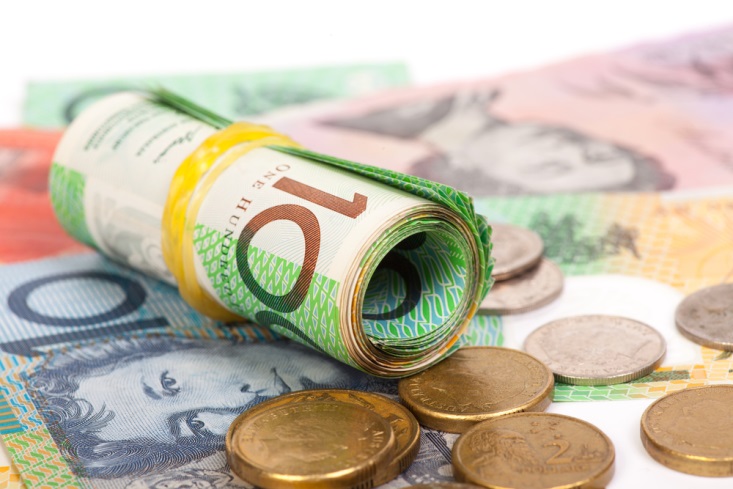 Rolled up Aussie dollar bills with coins