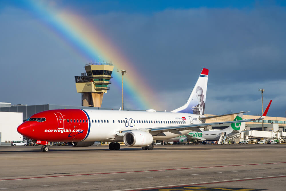 Norwegian Air: displaying a portrait of norwegian writer Johan Falkberget in front of a beautiful rainbow.
