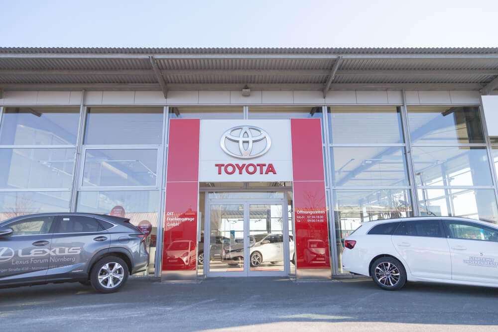 Toyota: Toyota logo near a car dealer building.