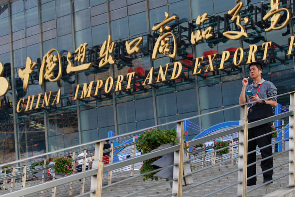  china’s imports: A man talks on his phone in front of China Import And Export Fair.