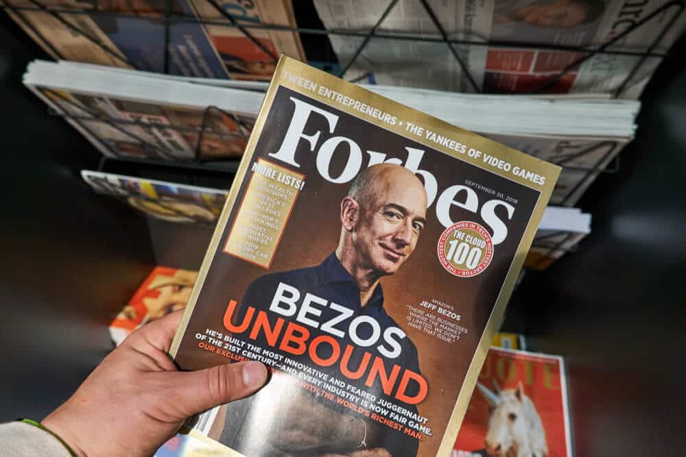 Revista Forbes con Jeff Bezos en la portada en la mano.