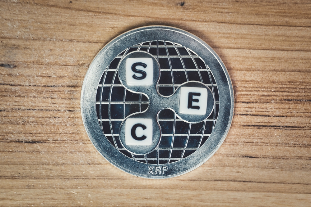 XRP coin with SEC letters on a wooden background, symbolizing the Ripple lawsuit with the Securities and Exchange Commission.
